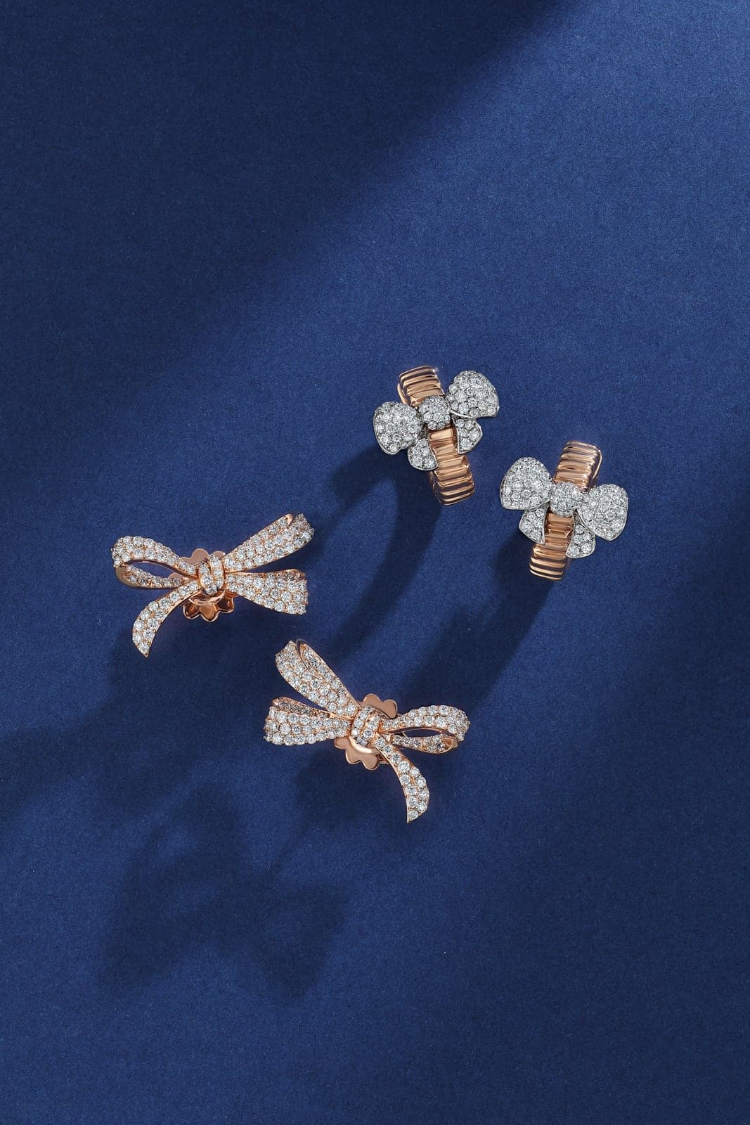 Three Fiocco bow pieces arranged on navy fabric