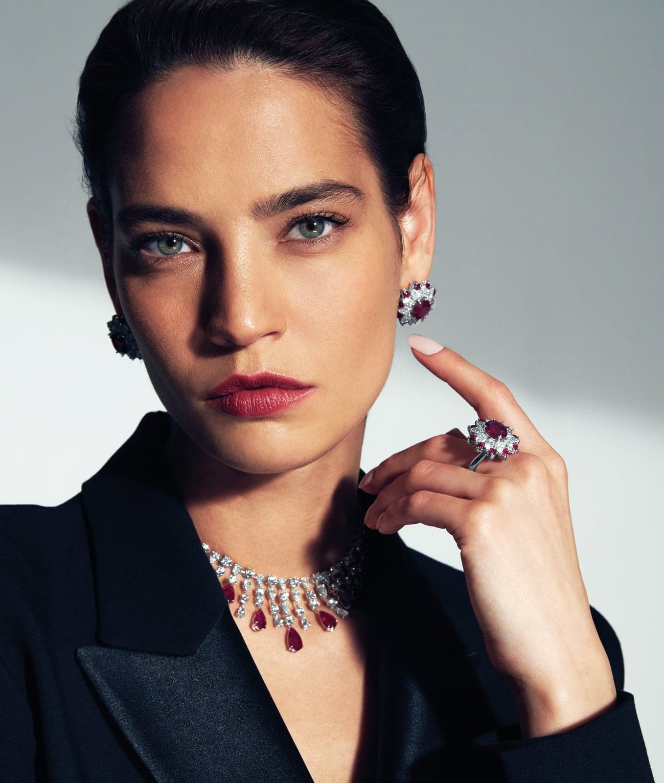 Ruby and diamond necklace, earrings and ring worn with a black jacket