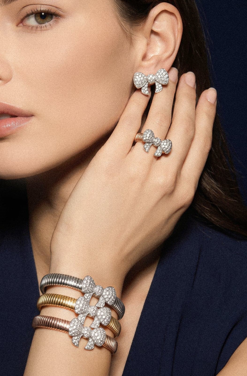 Fiocco bow earrings, rings and bracelets worn against navy