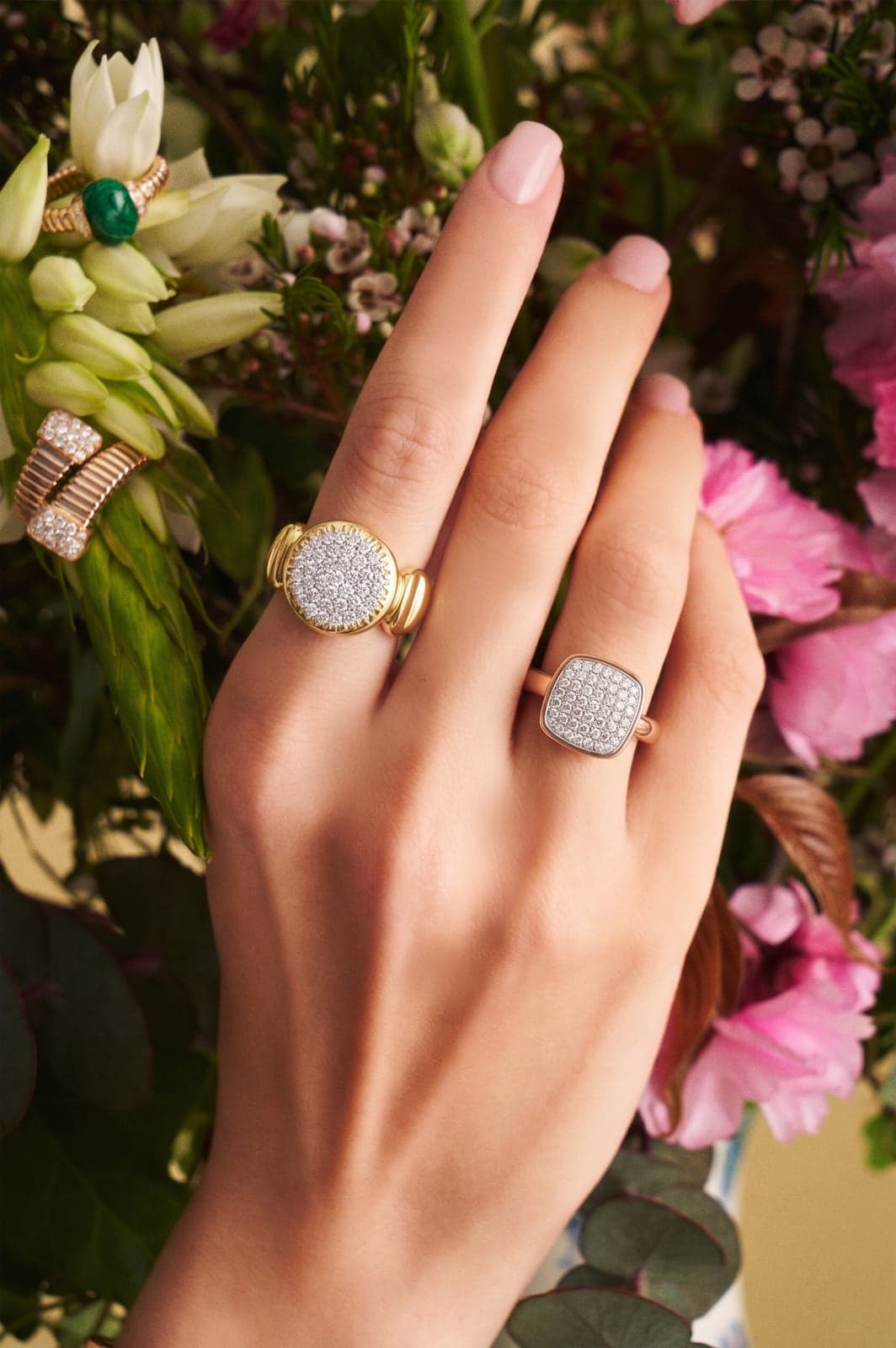 Toledo gold rings worn on a hand among flowers